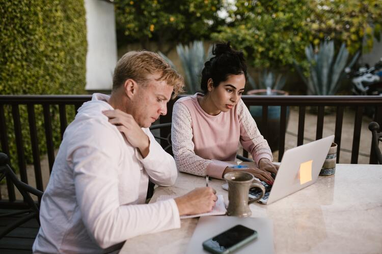 Two people working on a laptop