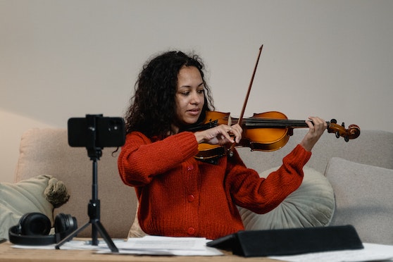 A woman teaching violin on the smartphone