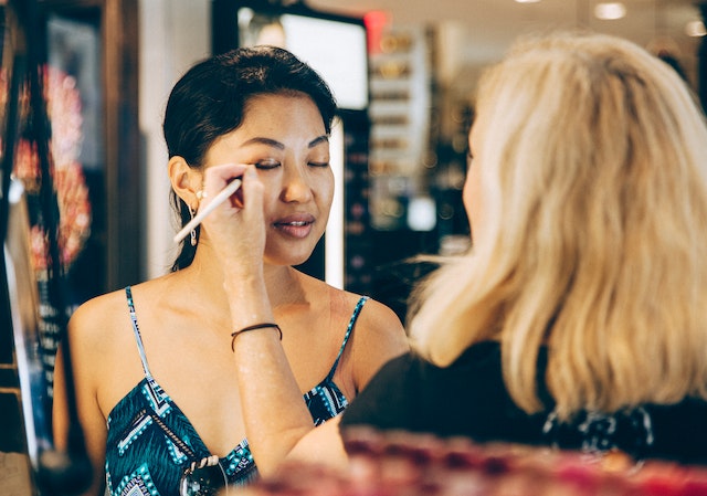 A person doing make-up on another person