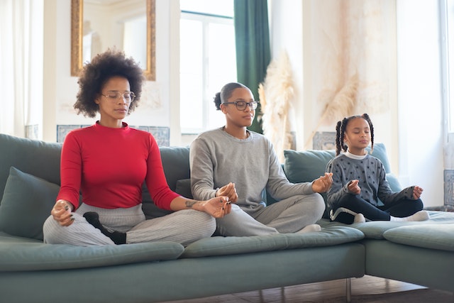 Three people meditating on the couch