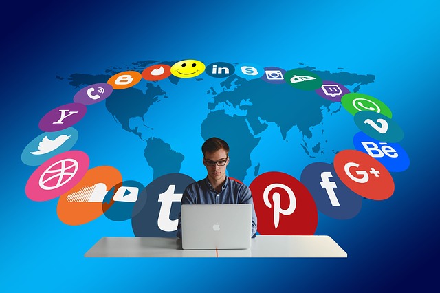 A person working on a laptop with a circle of social media company logos around him