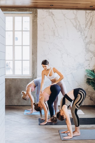 A woman correcting her student's posture