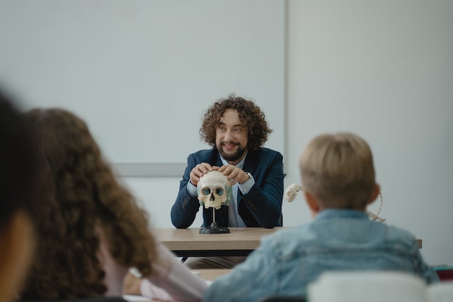 Teacher teaching his class with a skull