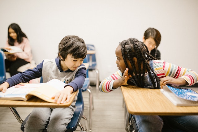 A k12 classroom with two kids discussing something