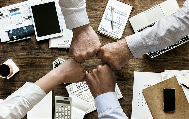 Four people fist-bumping