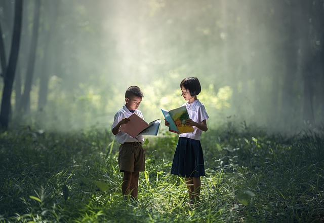 Two children in a forest reading books