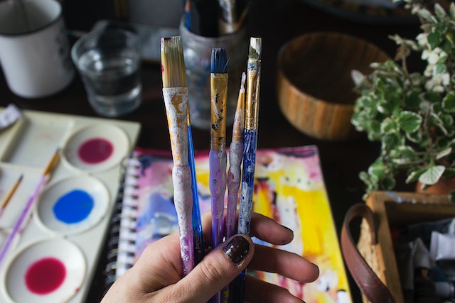 a hand holding art supplies