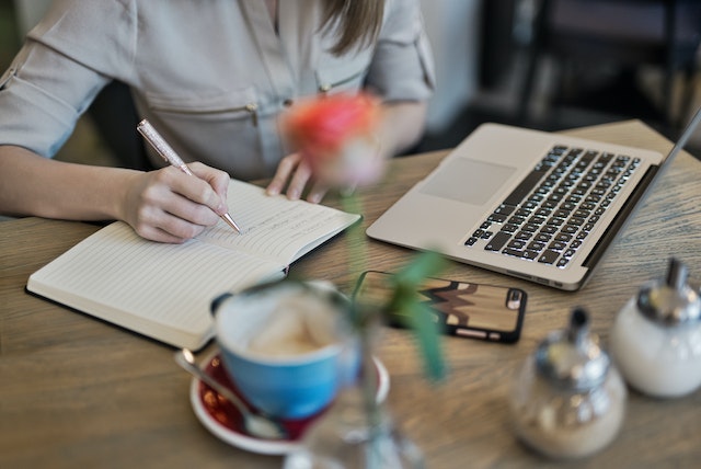 A person taking notes from a webinar