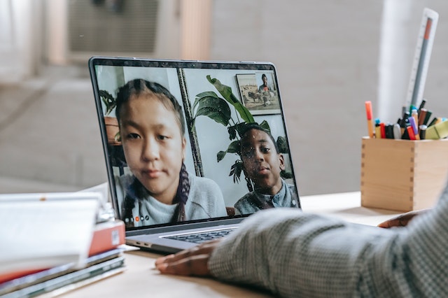 A person watching a screen with asian children in it