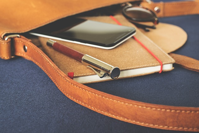 a book and phone in a leather satchel