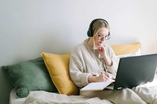 A person reading something on her laptop in a couch