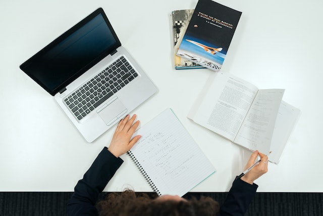 two laptops on a desk with a person learning