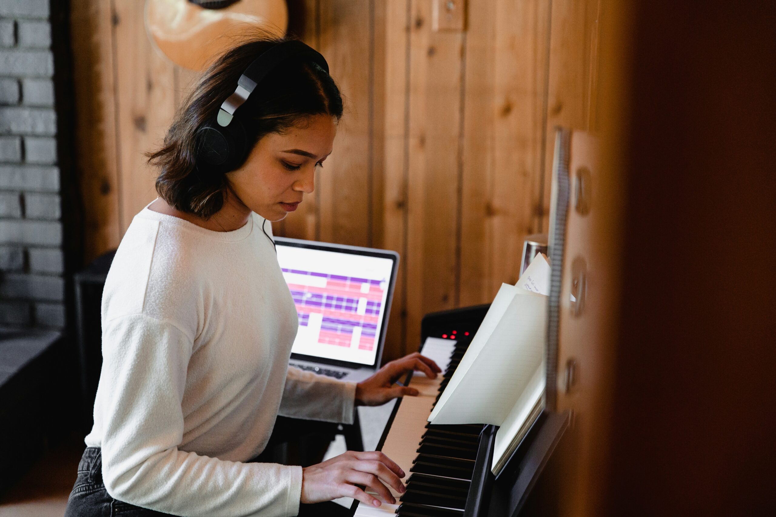 musician playing keyboard with a music school LMS or an LMS for music schools on macbook pro